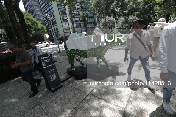 Persons are attending the inauguration of the 'Cowparade Mexico 2024' on Avenida Reforma in Mexico City, Mexico, on July 21, 2024. CowParade...