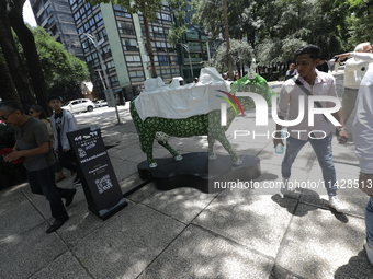 Persons are attending the inauguration of the 'Cowparade Mexico 2024' on Avenida Reforma in Mexico City, Mexico, on July 21, 2024. CowParade...