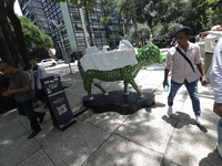 Persons are attending the inauguration of the 'Cowparade Mexico 2024' on Avenida Reforma in Mexico City, Mexico, on July 21, 2024. CowParade...