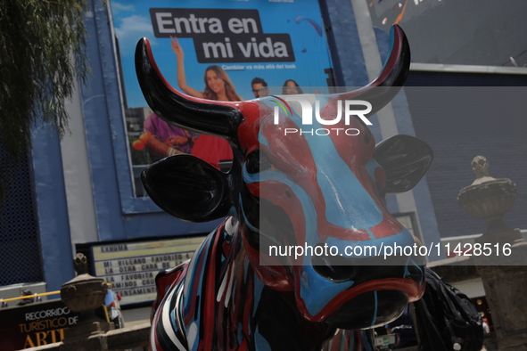 A fiberglass cow painting by an artist is being seen during the inauguration of the 'Cowparade Mexico 2024' on Avenida Reforma in Mexico Cit...