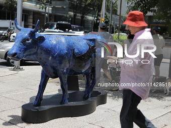 A man is being seen during the inauguration of the 'Cowparade Mexico 2024' on Avenida Reforma in Mexico City, Mexico, on July 21, 2024. CowP...