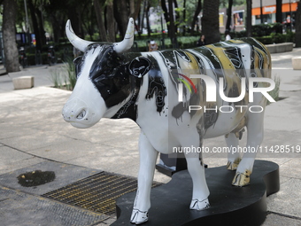 A fiberglass cow painting by an artist is being seen during the inauguration of the 'Cowparade Mexico 2024' on Avenida Reforma in Mexico Cit...