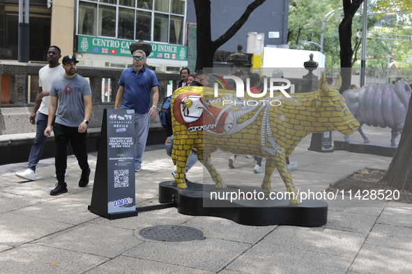 Persons are attending the inauguration of the 'Cowparade Mexico 2024' on Avenida Reforma in Mexico City, Mexico, on July 21, 2024. CowParade...