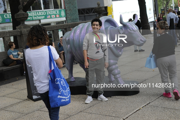 Persons are attending the inauguration of the 'Cowparade Mexico 2024' on Avenida Reforma in Mexico City, Mexico, on July 21, 2024. CowParade...