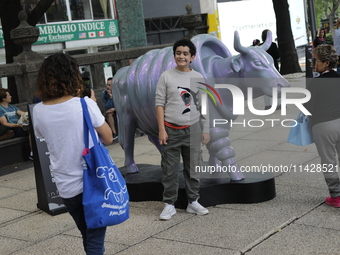 Persons are attending the inauguration of the 'Cowparade Mexico 2024' on Avenida Reforma in Mexico City, Mexico, on July 21, 2024. CowParade...