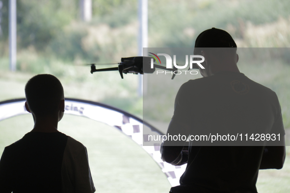 A man is flying a DJI drone during the 2nd Drone Racing Tournament by the Federation of Military Technological Sports of Ukraine in Bilohoro...