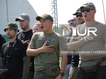 Participants in the 2nd Drone Racing Tournament by the Federation of Military Technological Sports of Ukraine are singing the national anthe...