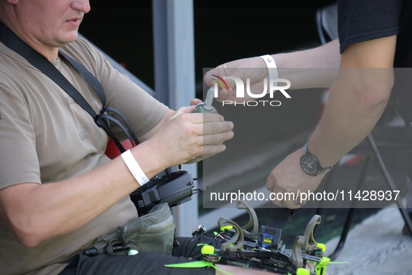 A participant in the 2nd Drone Racing Tournament by the Federation of Military Technological Sports of Ukraine is attaching a grenade to the...