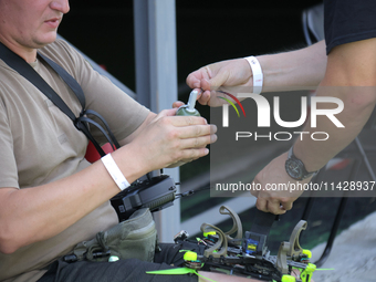 A participant in the 2nd Drone Racing Tournament by the Federation of Military Technological Sports of Ukraine is attaching a grenade to the...