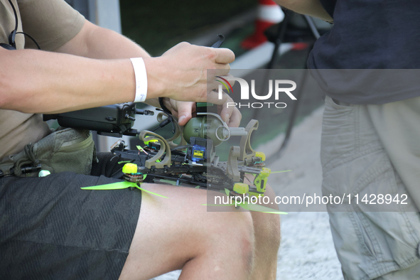 A participant in the 2nd Drone Racing Tournament by the Federation of Military Technological Sports of Ukraine is attaching a grenade to the...