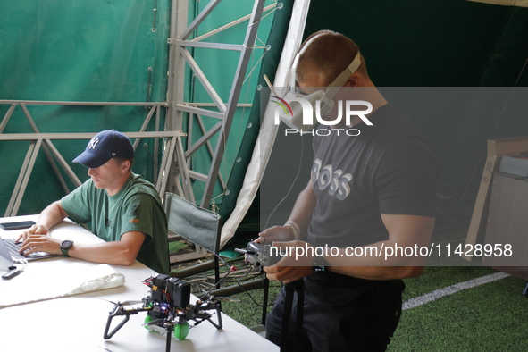 A participant in the 2nd Drone Racing Tournament by the Federation of Military Technological Sports of Ukraine is setting up a drone in Bilo...