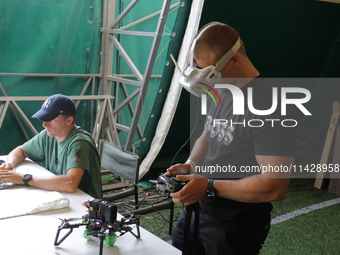 A participant in the 2nd Drone Racing Tournament by the Federation of Military Technological Sports of Ukraine is setting up a drone in Bilo...