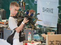 A boy is looking at a drone on display during the 2nd Drone Racing Tournament by the Federation of Military and Technological Sports of Ukra...