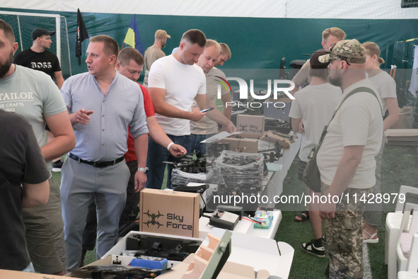 Visitors are looking at the items of the exhibition held as part of the 2nd Drone Racing Tournament by the Federation of Military and Techno...