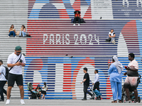 PARIS, FRANCE - JULY 22:   
People gather around the steps of the Grande Arche adorned with Olympic-themed graphics, celebrating the upcomin...