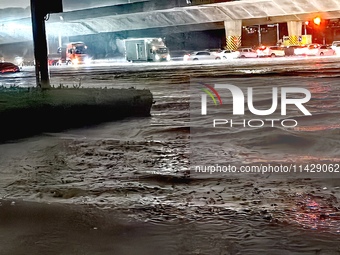 Vehicles are driving in a flooded area after heavy rain in Zhengzhou, China, on July 22, 2024. (