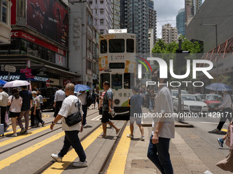 People are crossing the road in Hong Kong, China, on July 22, 2024. (