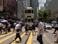 People are crossing the road in Hong Kong, China, on July 22, 2024. (