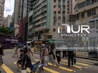 People are crossing the road in Hong Kong, China, on July 22, 2024. (