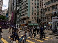 People are crossing the road in Hong Kong, China, on July 22, 2024. (