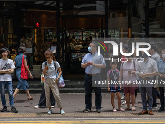 People are crossing the road in Hong Kong, China, on July 22, 2024. (