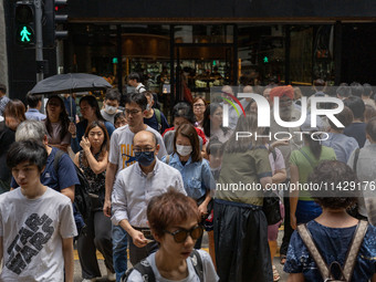 People are crossing the road in Hong Kong, China, on July 22, 2024. (