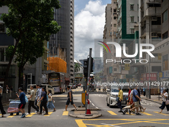 People are crossing the road in Hong Kong, China, on July 22, 2024. (