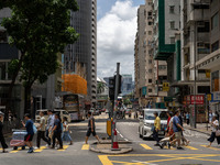 People are crossing the road in Hong Kong, China, on July 22, 2024. (