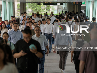 People are walking on a footbridge in Hong Kong, on July 22, 2024. (