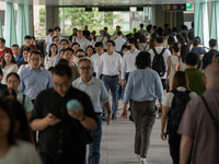 People are walking on a footbridge in Hong Kong, on July 22, 2024. (