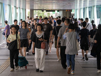 People are walking on a footbridge in Hong Kong, on July 22, 2024. (