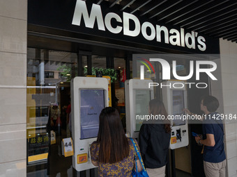 People are ordering from machines at a McDonald's in Hong Kong, on July 22, 2024. (