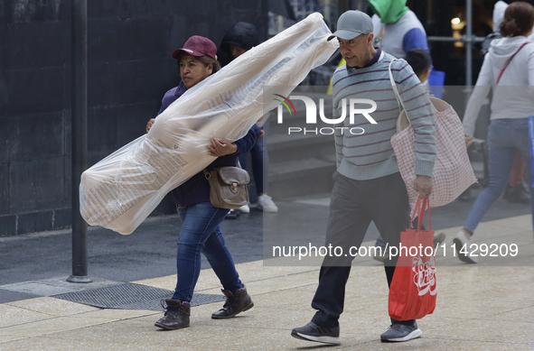 A view of passers-by in the centre of Mexico City, Mexico, on Monday, after Mexico City is reaching a record temperature of 34.2 degrees Cel...