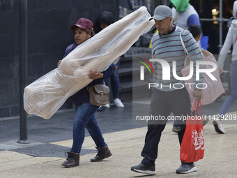 A view of passers-by in the centre of Mexico City, Mexico, on Monday, after Mexico City is reaching a record temperature of 34.2 degrees Cel...