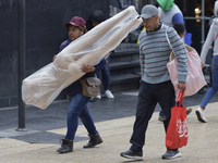 A view of passers-by in the centre of Mexico City, Mexico, on Monday, after Mexico City is reaching a record temperature of 34.2 degrees Cel...