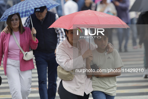 A view of passers-by in the centre of Mexico City, Mexico, on Monday, after Mexico City is reaching a record temperature of 34.2 degrees Cel...