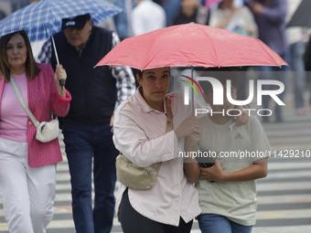 A view of passers-by in the centre of Mexico City, Mexico, on Monday, after Mexico City is reaching a record temperature of 34.2 degrees Cel...