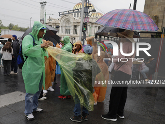 Passers-by are taking shelter in the centre of Mexico City, Mexico, on Monday, after the city reached a record temperature of 34.2 degrees C...