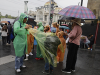 Passers-by are taking shelter in the centre of Mexico City, Mexico, on Monday, after the city reached a record temperature of 34.2 degrees C...