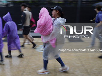 Passers-by are taking shelter in the centre of Mexico City, Mexico, on Monday, after the city reached a record temperature of 34.2 degrees C...