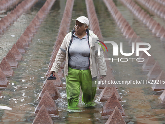 A person is taking shelter from the rain in downtown Mexico City, Mexico, on Monday. After Mexico City reached a record temperature of 34.2...