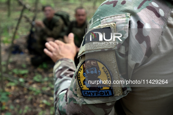 A shoulder sleeve patch is on a serviceman of the Smurfs Task Force Police Regiment during a tactical exercise in Ukraine, on July 22, 2024....