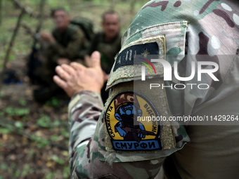 A shoulder sleeve patch is on a serviceman of the Smurfs Task Force Police Regiment during a tactical exercise in Ukraine, on July 22, 2024....