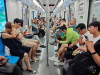 Passengers are looking at their mobile phones during the operation of Metro Line 8 in Shanghai, China, on July 23, 2024. (