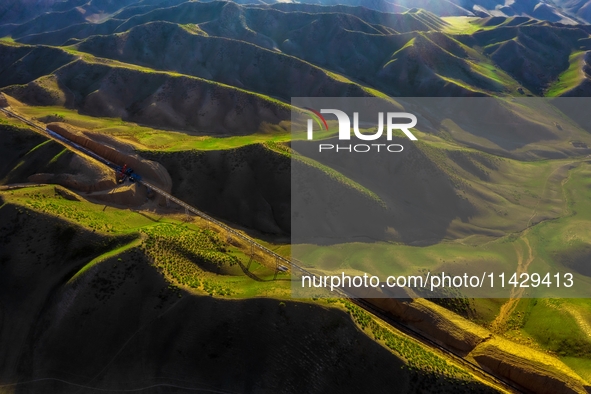 Workers are installing and inspecting a coal transport corridor on Road 147 in Hutubi County, Changji Hui Autonomous Prefecture, Xinjiang, C...