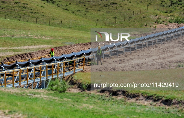 Workers are installing and inspecting a coal transport corridor on Road 147 in Hutubi County, Changji Hui Autonomous Prefecture, Xinjiang, C...