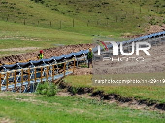 Workers are installing and inspecting a coal transport corridor on Road 147 in Hutubi County, Changji Hui Autonomous Prefecture, Xinjiang, C...