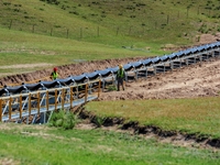 Workers are installing and inspecting a coal transport corridor on Road 147 in Hutubi County, Changji Hui Autonomous Prefecture, Xinjiang, C...