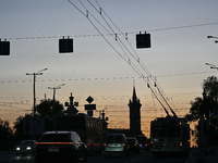 Cars are on the road at night as the city is switching off street lights due to power shortages in the region and to save electricity for re...