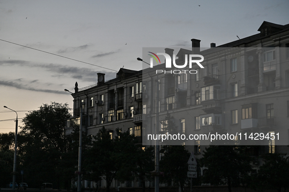 An apartment building is being seen at dusk as the city is switching off street lights due to power shortages in the region and to save elec...